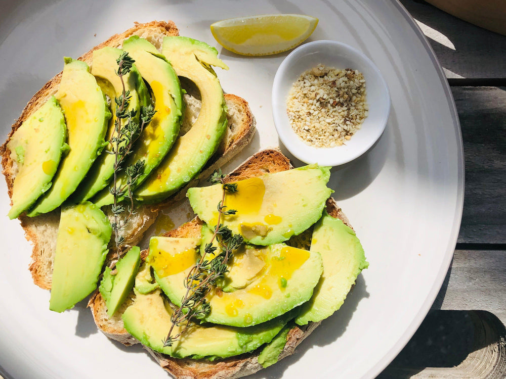 Avocado on sourdough toast drizzled with olive oil and Classic Dukkah at the side